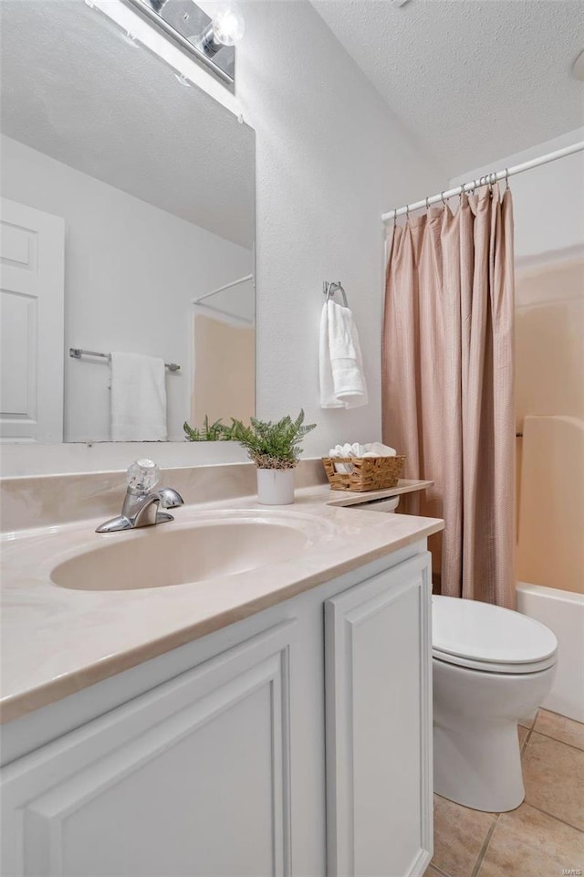 full bathroom featuring toilet, a textured ceiling, shower / tub combo with curtain, tile patterned floors, and vanity