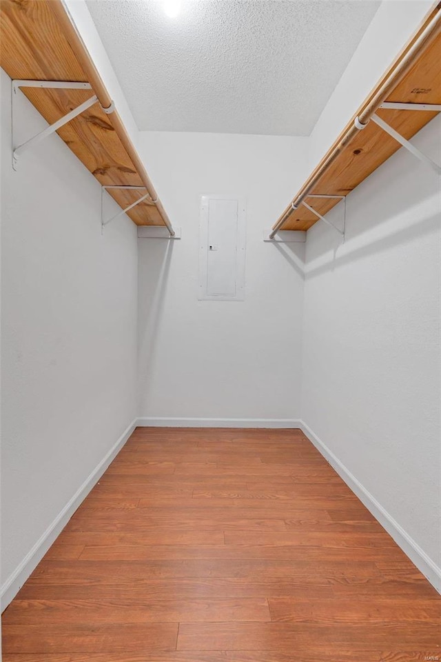 walk in closet with wood-type flooring and electric panel