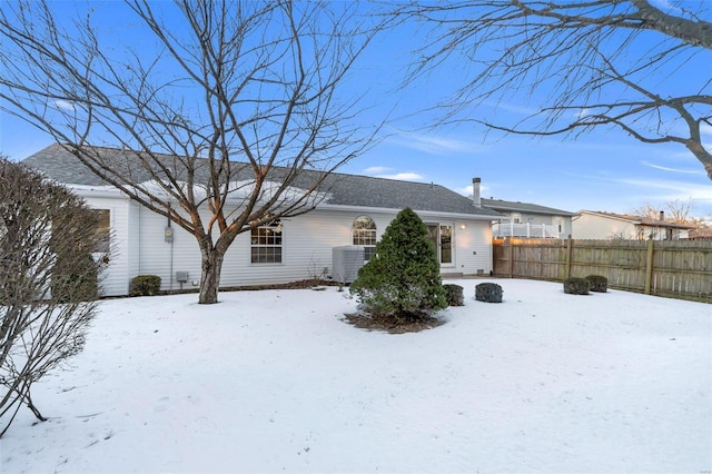 snow covered house with central AC unit