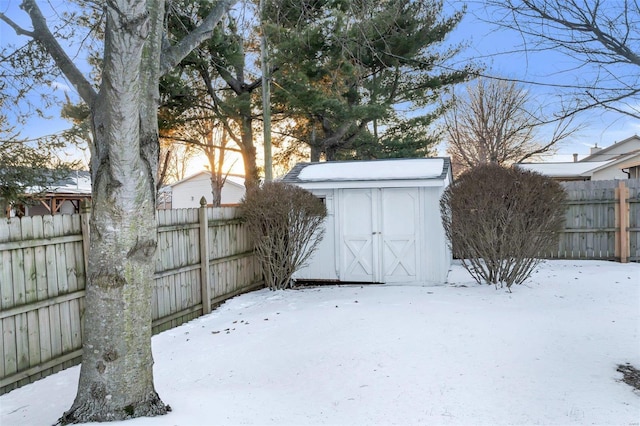 yard covered in snow with a storage shed