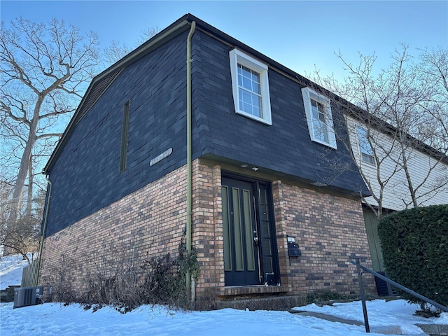 view of snowy exterior featuring central AC unit