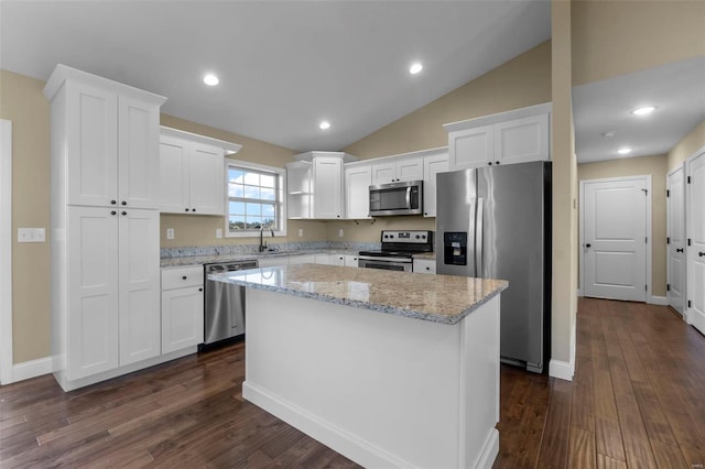 kitchen featuring sink, white cabinetry, a kitchen island, stainless steel appliances, and light stone countertops