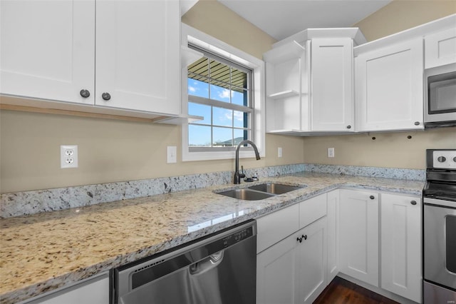 kitchen with light stone counters, sink, stainless steel appliances, and white cabinets