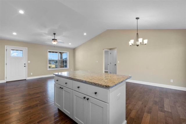 kitchen featuring dark hardwood / wood-style floors, pendant lighting, white cabinets, and light stone counters