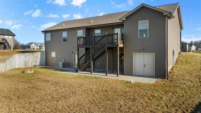 rear view of property featuring cooling unit, a lawn, a patio, and a deck