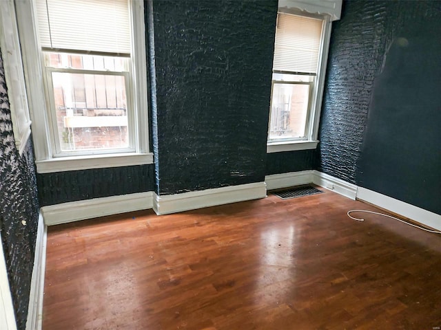 spare room featuring hardwood / wood-style floors and a wealth of natural light