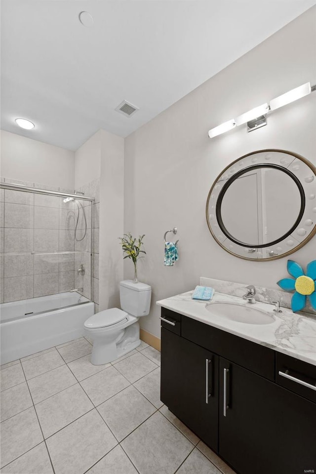 full bathroom featuring tile patterned flooring, vanity, tiled shower / bath combo, and toilet