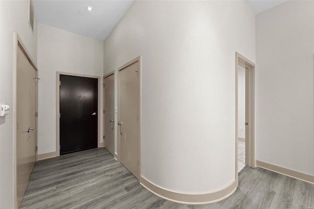 hallway with a high ceiling and light wood-type flooring