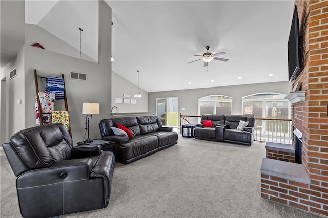 carpeted living room with high vaulted ceiling, a fireplace, visible vents, and recessed lighting