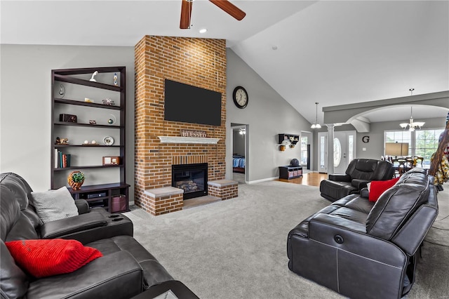 living room featuring arched walkways, high vaulted ceiling, ceiling fan with notable chandelier, carpet flooring, and a brick fireplace