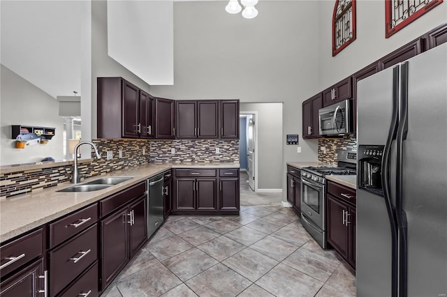 kitchen featuring light tile patterned floors, a sink, dark brown cabinets, appliances with stainless steel finishes, and decorative backsplash