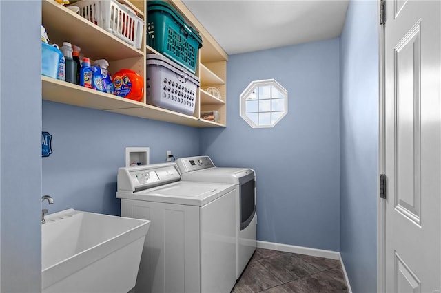 laundry area featuring washing machine and dryer, laundry area, a sink, and baseboards