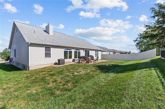 back of property featuring a patio, a chimney, a lawn, fence, and cooling unit