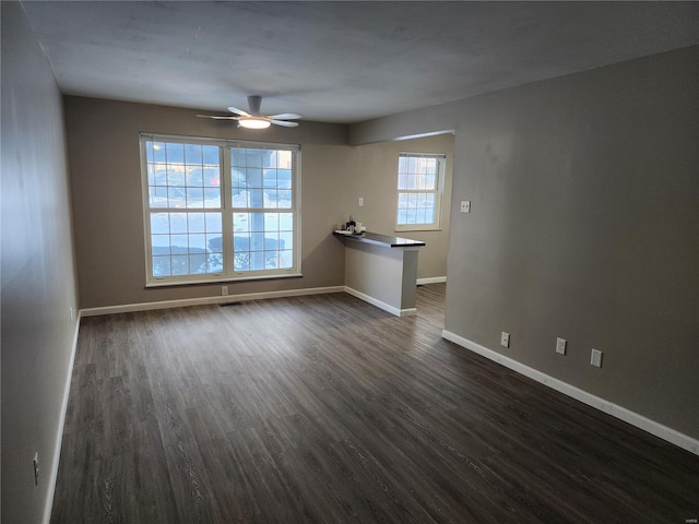 spare room with ceiling fan and dark wood-type flooring