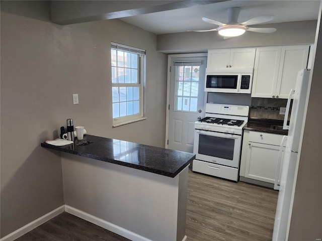 kitchen featuring white appliances, white cabinets, kitchen peninsula, and tasteful backsplash