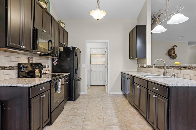 kitchen featuring sink, light stone counters, decorative light fixtures, dark brown cabinets, and black appliances