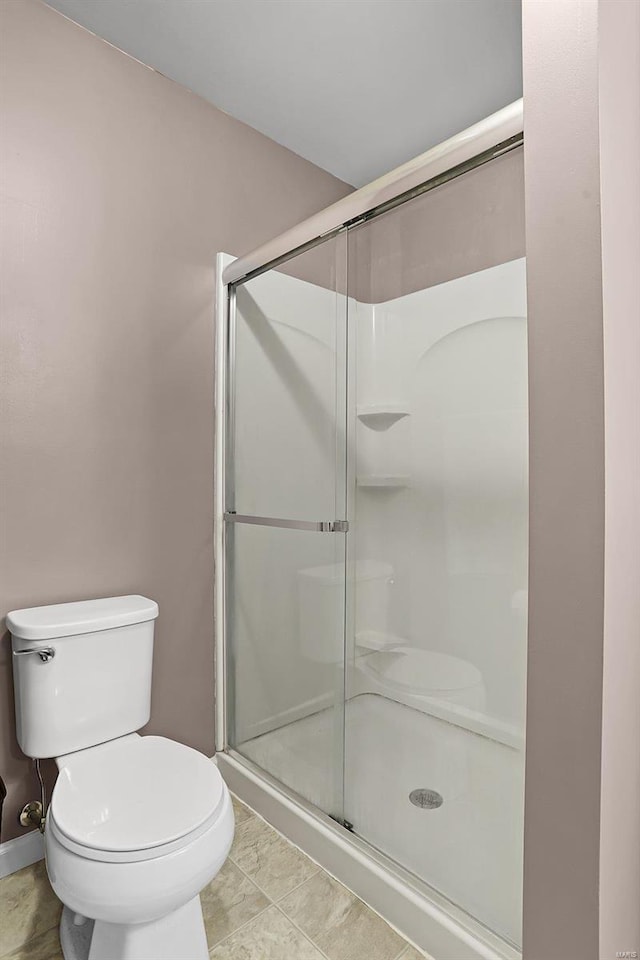 bathroom with a shower with door and toilet