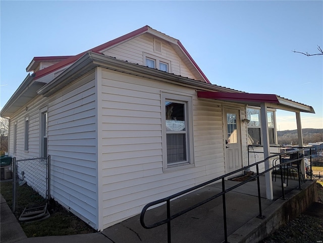 view of side of property featuring covered porch