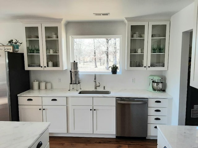 bar featuring sink, white cabinetry, stainless steel appliances, light stone countertops, and dark hardwood / wood-style flooring