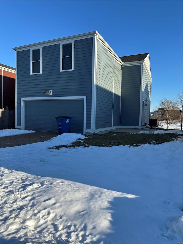 view of snowy exterior featuring a garage