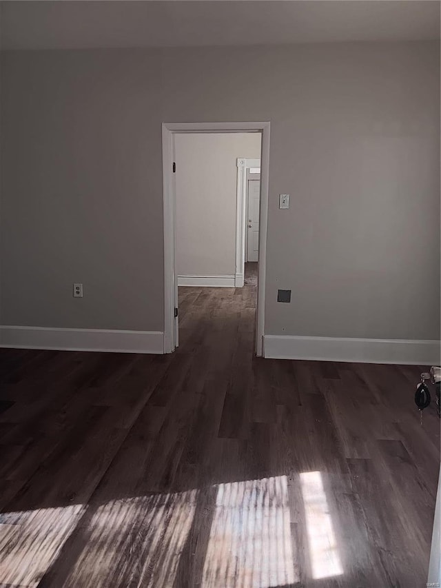 spare room featuring dark wood-type flooring