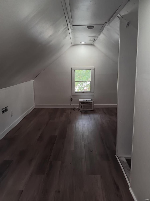 bonus room featuring vaulted ceiling, dark hardwood / wood-style floors, and a wall mounted air conditioner