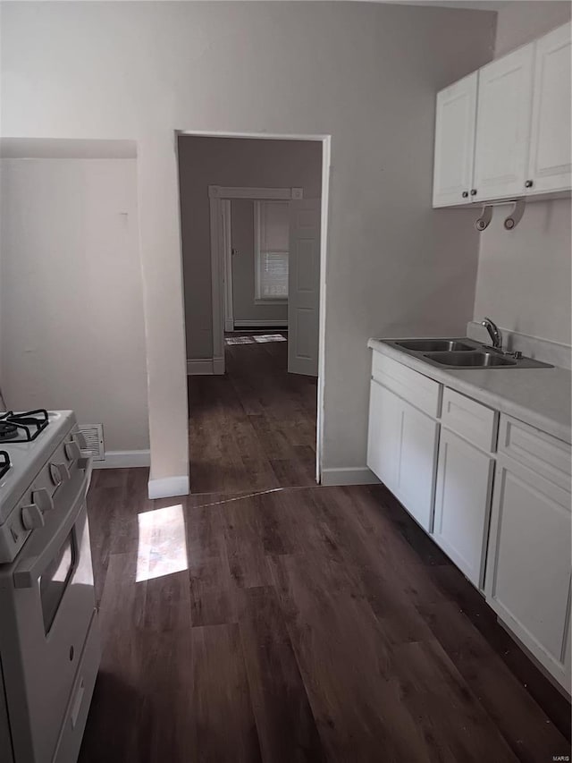 kitchen featuring white cabinetry, dark hardwood / wood-style floors, sink, and white range with gas cooktop