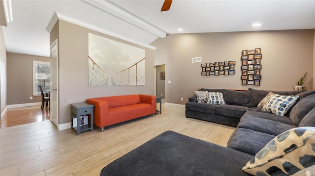 living room with ceiling fan, vaulted ceiling with beams, and light wood-type flooring