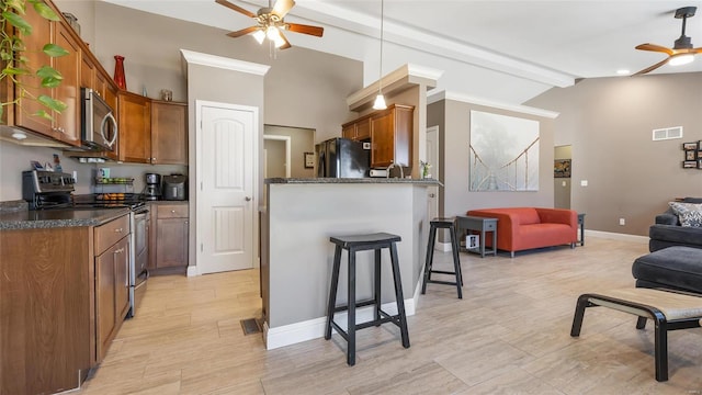 kitchen featuring beamed ceiling, a kitchen bar, ceiling fan, stainless steel appliances, and light hardwood / wood-style flooring