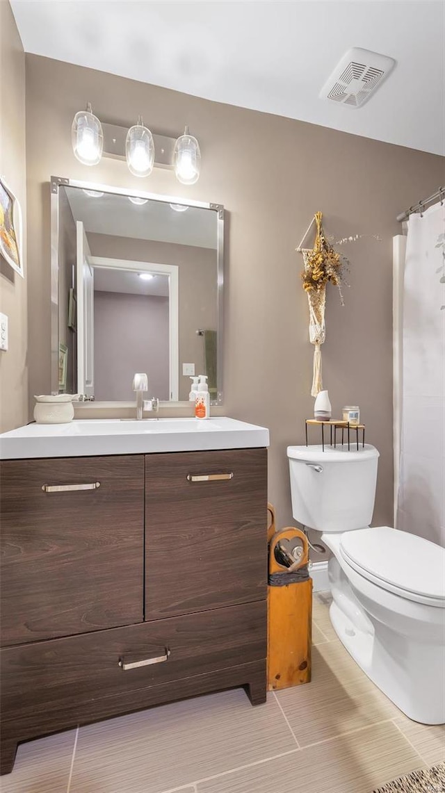 bathroom with tile patterned flooring, vanity, and toilet