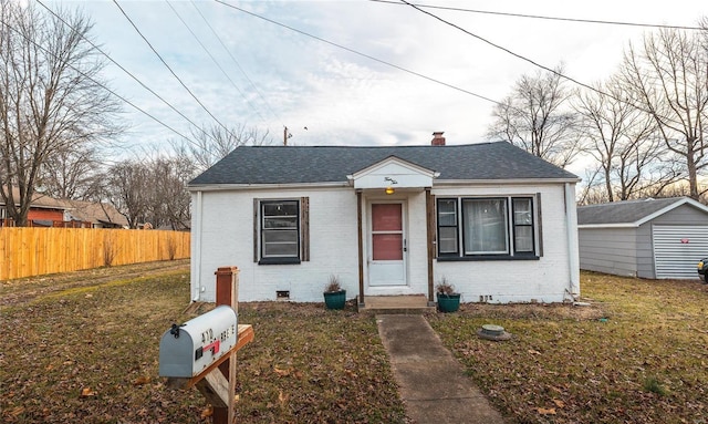 bungalow-style home with a shingled roof, a chimney, crawl space, fence, and brick siding