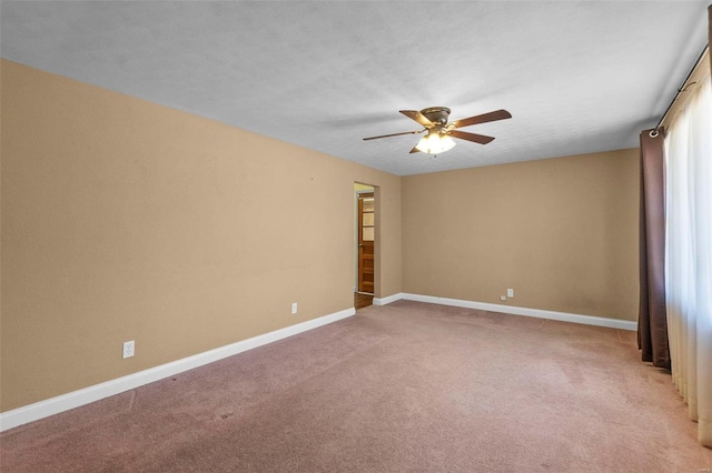 spare room with ceiling fan, light colored carpet, and a textured ceiling