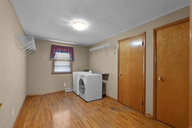 laundry room featuring independent washer and dryer and light wood-type flooring