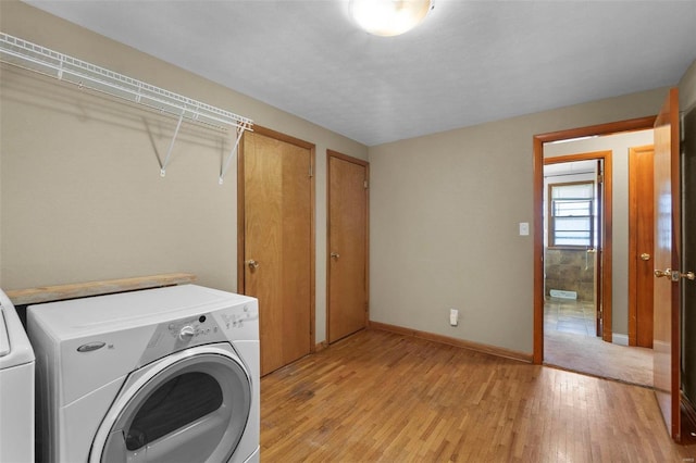 washroom with light hardwood / wood-style floors and separate washer and dryer