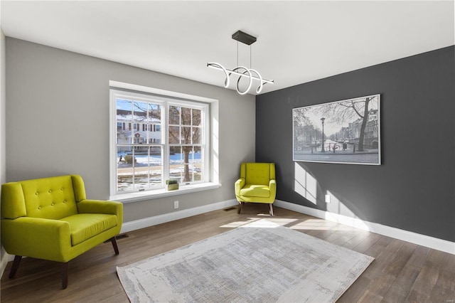 living area with hardwood / wood-style flooring and a chandelier