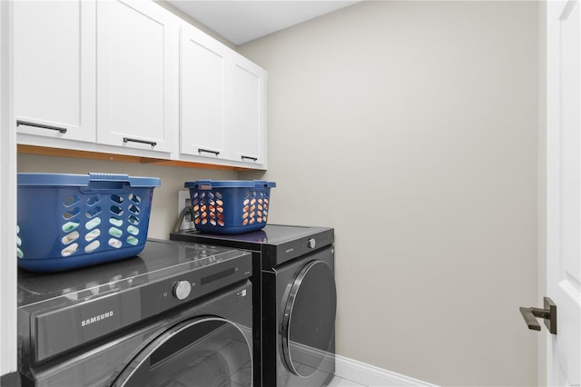 laundry room featuring cabinets, tile patterned flooring, and washer and clothes dryer