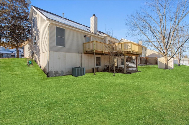 back of property with a wooden deck, a lawn, and cooling unit