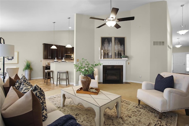 living room with ceiling fan and high vaulted ceiling