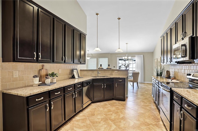 kitchen with appliances with stainless steel finishes, hanging light fixtures, sink, dark brown cabinets, and light stone counters