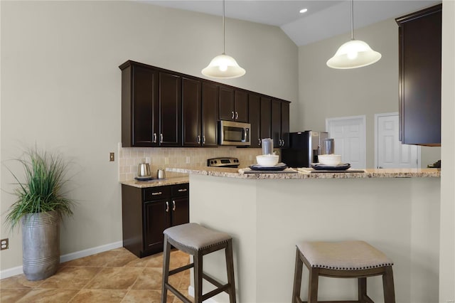 kitchen with decorative light fixtures, tasteful backsplash, a breakfast bar, and appliances with stainless steel finishes