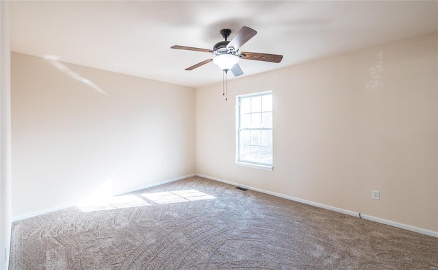 carpeted spare room with ceiling fan