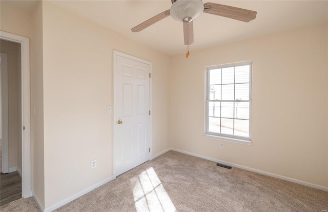 carpeted empty room featuring ceiling fan