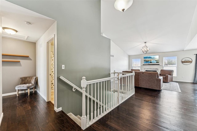 corridor with vaulted ceiling and dark hardwood / wood-style floors