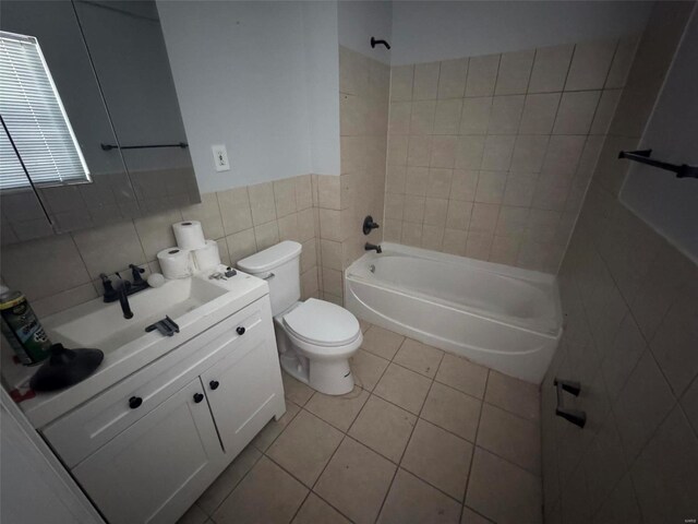 full bathroom featuring tile walls, tile patterned flooring, vanity, toilet, and tiled shower / bath