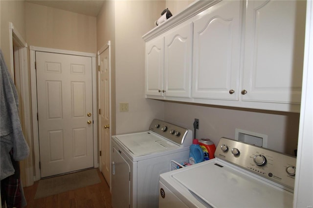 laundry area with dark wood-type flooring, cabinets, and separate washer and dryer