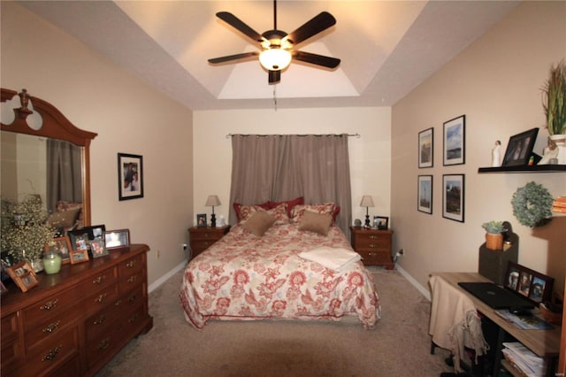 carpeted bedroom featuring ceiling fan and a raised ceiling