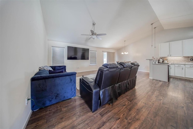 living room featuring vaulted ceiling, dark hardwood / wood-style floors, and ceiling fan