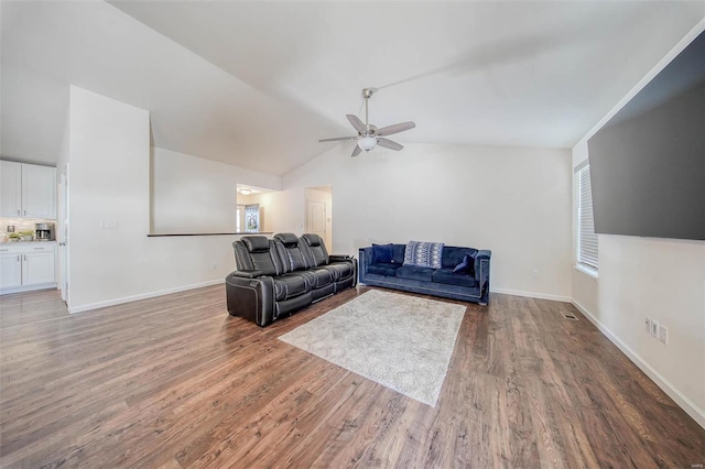 living room with hardwood / wood-style flooring, ceiling fan, and vaulted ceiling