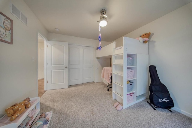 bedroom featuring light carpet, ceiling fan, and a closet