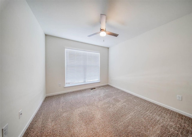 carpeted spare room featuring ceiling fan